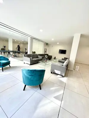 a large living room with couches and a blue chair at Emerald Suites in Protaras