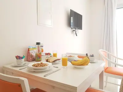 a breakfast table with breakfast foods and orange juice at Christos Napa Self Serviced Apartments in Ayia Napa