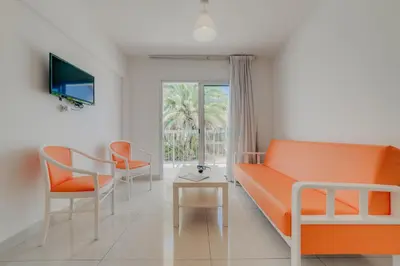 a living room with an orange couch and chairs at Christos Napa Self Serviced Apartments in Ayia Napa