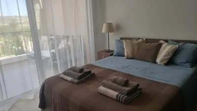 a bedroom with a bed with two towels on it at Pyla Gardens A202 Studio in Pyla