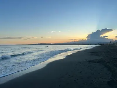 a beach with the sun setting in the distance at Mersey Faros Complex in Pervolia
