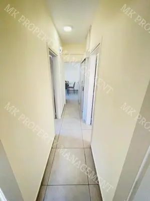 a corridor of a room with white walls and a tile floor at Milos City Center Apts No.34 in Larnaka