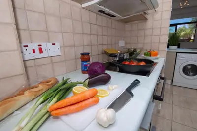 a kitchen counter with carrots and onions on a cutting board at Mylos 9 in Protaras