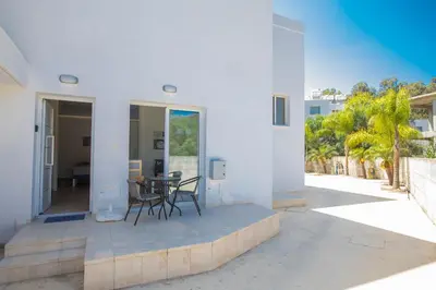 a white house with a patio with a table and chairs at Panayia Sea View Apts in Protaras