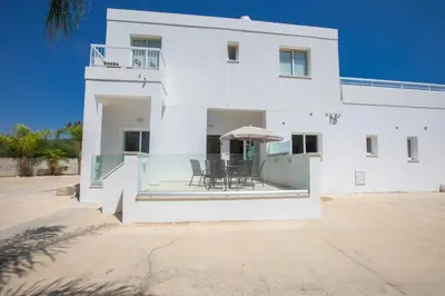 a white house with a table and chairs at Panayia Sea View Apts in Protaras