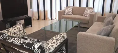 a living room with a couch and a glass table at Apartment Sleeps 6 with Ensuite in Nicosia