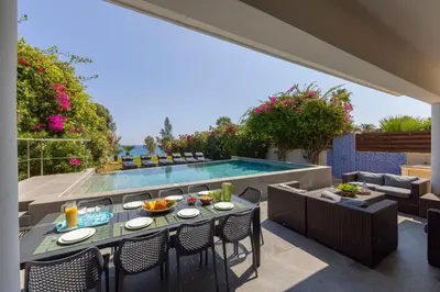 a patio with a table and chairs and a swimming pool at Villa Adalia in Protaras