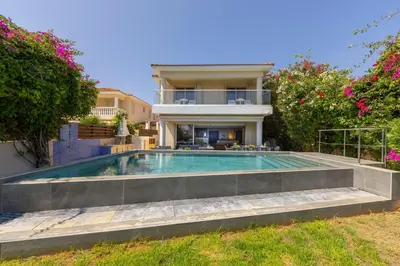 a villa with a swimming pool in front of a house at Villa Adalia in Protaras