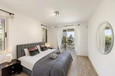 a bedroom with a large bed and two mirrors at Villa Adalia in Protaras