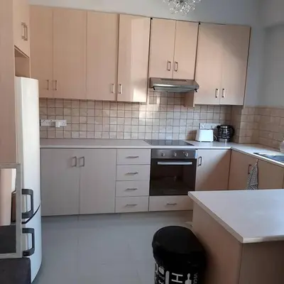 a kitchen with white cabinets and a stove top oven at Universe House in Mor Menekshe