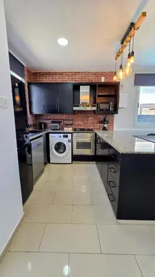 a large kitchen with black cabinets and appliances at Sweet Destiny Villa with private pool in Ayia Napa