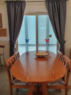 a dining room table with chairs and a large window at Melanta Villa in Pissouri