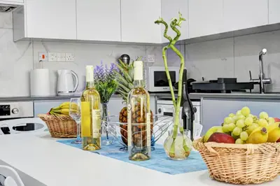 a kitchen counter with bottles of wine and baskets of fruit at MyHome DeLux, Ayia Napa 3 Bedroom with Pool in Ayia Napa