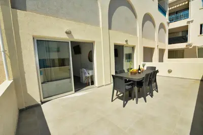 a black table and chairs on the patio of a building at MyHome DeLux, Ayia Napa 3 Bedroom with Pool in Ayia Napa