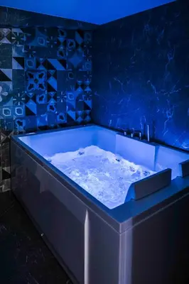 a blue bath tub in a room with blue tiles at Kamaroporta Luxury Apartments in Ayios Theodhoros