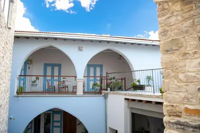 a white building with arches and a balcony at 7Kamares in Pano Lefkara