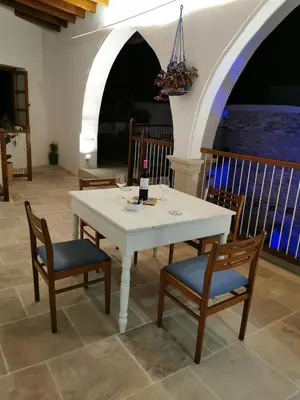 a white table with two chairs and a bottle of wine at 7Kamares in Pano Lefkara