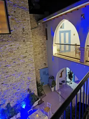 a room with purple walls and a stone wall at 7Kamares in Pano Lefkara