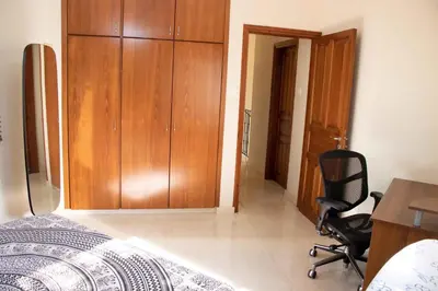 a bedroom with a bed and a desk and a chair at VillaHoliday in Voroklini