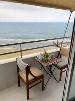 a balcony with a table and chairs and the beach at Larnaca Room, 50m to the Finikoudes beach in Larnaka