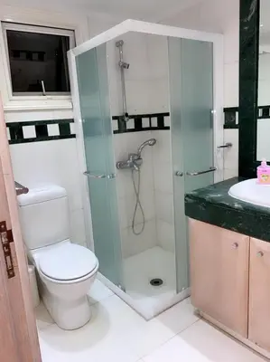 a bathroom with a shower and a toilet and a sink at Larnaca Room, 50m to the Finikoudes beach in Larnaka