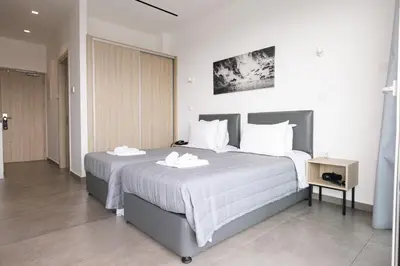a bedroom with a large bed with two towels on it at Caramela Luxury Apts in Ayia Napa