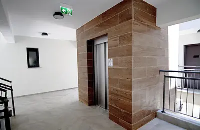 a hallway with a wooden wall in a building at Golden Tree Apartment in Paralimni
