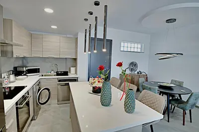 a kitchen with a table with vases on it at Golden Tree Apartment in Paralimni