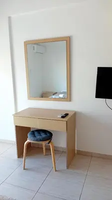 a desk with a mirror and a chair in a room at Napa Charles Apts in Ayia Napa