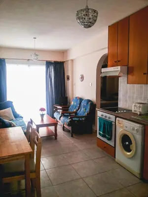 a kitchen and living room with a couch and a table at Apartments Mackenzie 1+1 in Larnaka