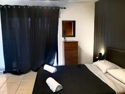 a bedroom with a bed and a black curtain at St Lazaros, Larnaca Center Studio in Scala