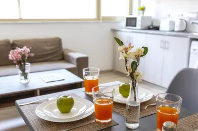 a table with two plates and glasses of orange juice at C-Premium Apts 100m from beach and city centre in Larnaka