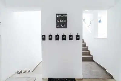a staircase with white walls and a clock on the wall at Spiros Luxury Apartments in Ayia Napa