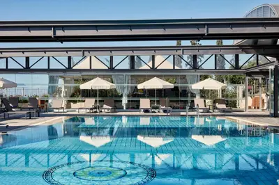 a large swimming pool with chairs and umbrellas at Atlantica Bay - Adults Only in Limassol