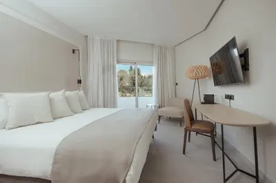 a hotel room with a bed and a desk and a table at Atlantica Bay - Adults Only in Limassol