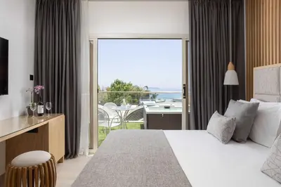 a bedroom with a bed and a view of the ocean at Atlantica Bay - Adults Only in Limassol