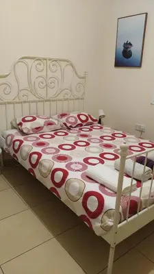 a bed with a red and white blanket on it at Larnaca Xylophagou 2-bedroom apartment with a shaded terrace in Xylophaghou