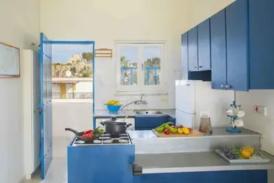 a kitchen with blue cabinets and a stove top oven at Vitamin Sea Protaras in Protaras
