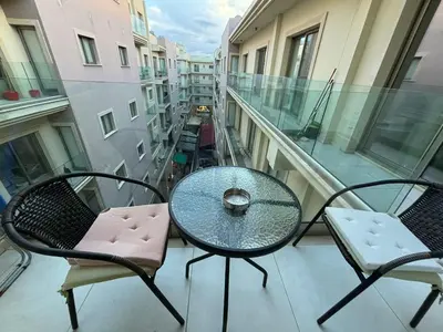 a balcony with a table and chairs on a building at Central Large Apt Next to the Beach in Larnaka