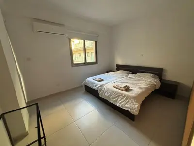 a bedroom with a bed with two towels on it at Central Large 2BD APT near the Beach in Larnaka