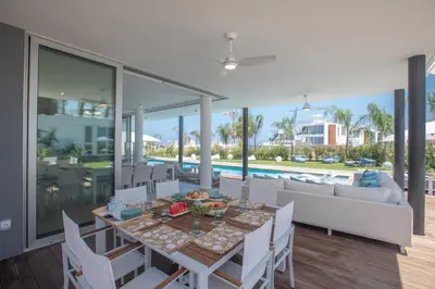 a dining room with a table and chairs and a couch at Villa Olivine Pearl 3 in Protaras