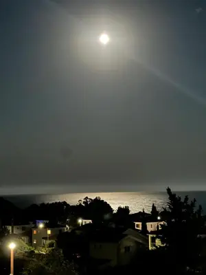 a full moon over the ocean at night at Pissouri Image in Pissouri