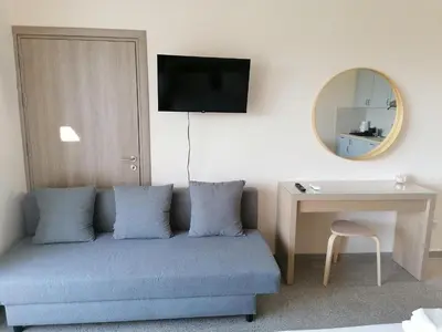 a room with a couch and a table and a mirror at Pissouri Image in Pissouri