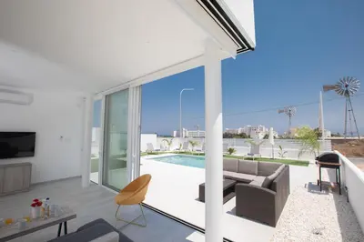 a living room with a couch and a pool at Walk to Protaras Center & Beach- Your Dream Escape, Blue Island Villa in Protaras