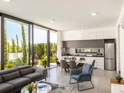 a kitchen and living room with a couch and chairs at Almaria Residences in Paralimni