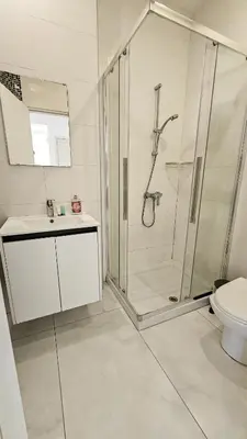 a bathroom with a shower and a sink and a toilet at Mimi's Sunny Beach Apartment in Larnaka
