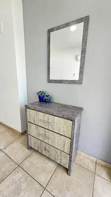 a dresser in a room with a mirror on the wall at FlipFlop City Center Apartment in Larnaka