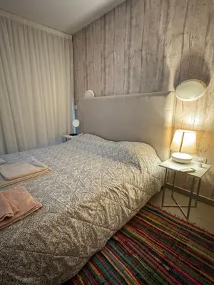 a bedroom with a bed and a table with a lamp at One-bedroom beach apartment, 30m from an amazing beach, Coralli in Protaras