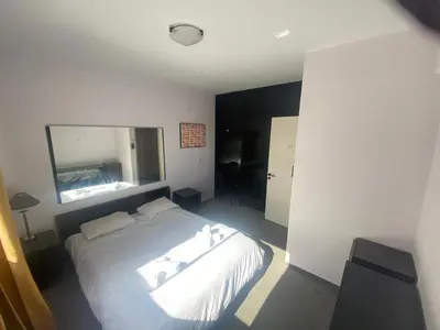 a bedroom with a white bed and a mirror at private room in a shared flat at best location in Limassol