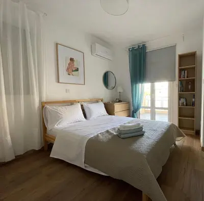 a bedroom with a large bed with blue curtains at Lovely 1-bd apt with patio in Nicosia center in Nicosia